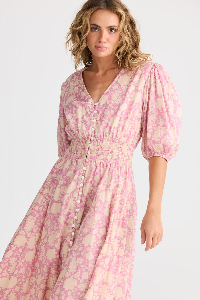Woman wearing a pink floral dress on a white background