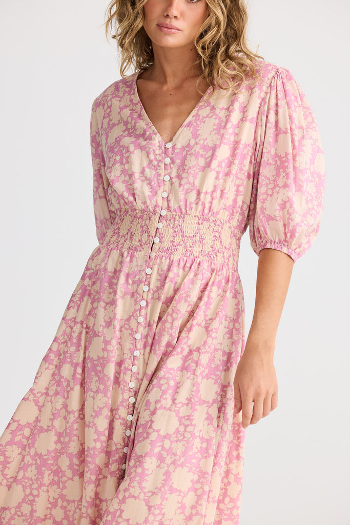 Woman wearing a pink floral dress on a white background