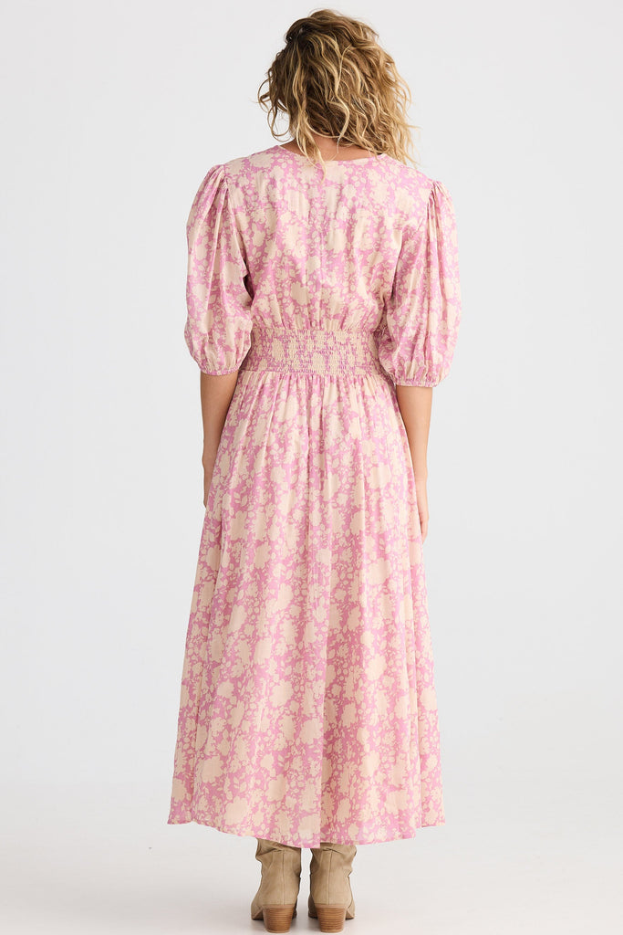 Woman wearing a pink floral dress on a white background