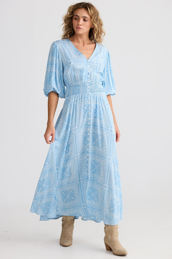 Woman wearing a light blue dress with a plain background