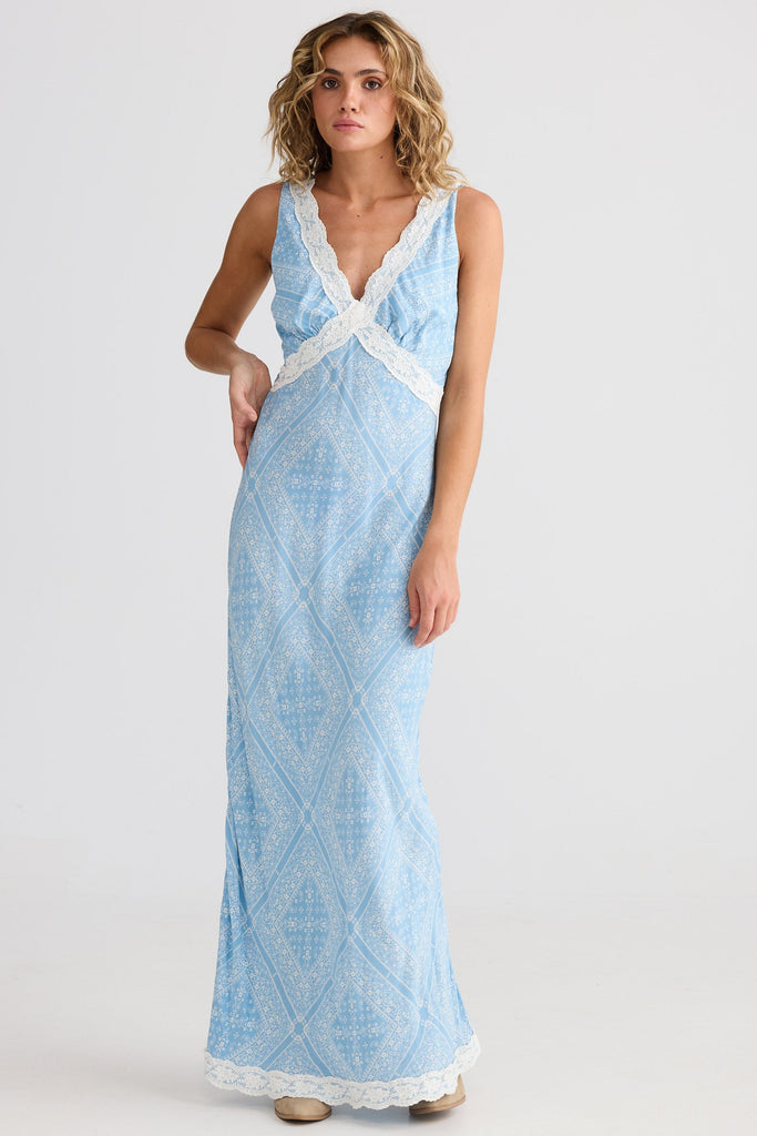 Woman wearing a light blue dress with white lace details on a white background
