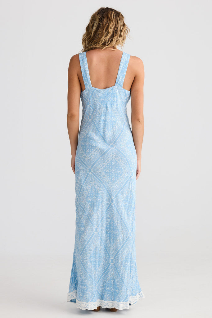 Woman wearing a light blue patterned dress on a white background