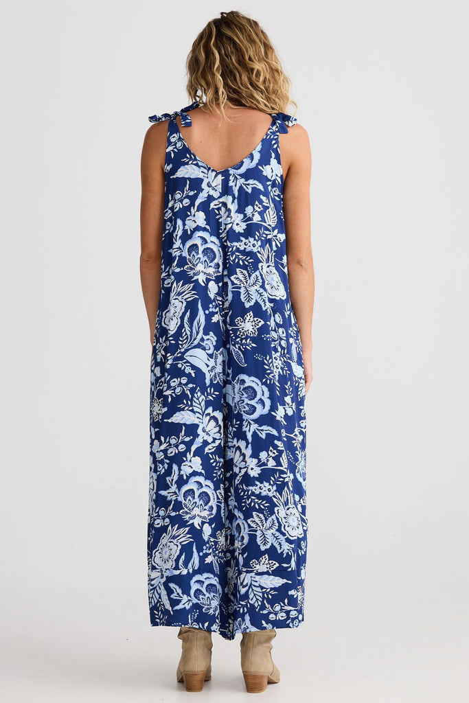 Woman wearing a blue floral jumpsuit on a white background