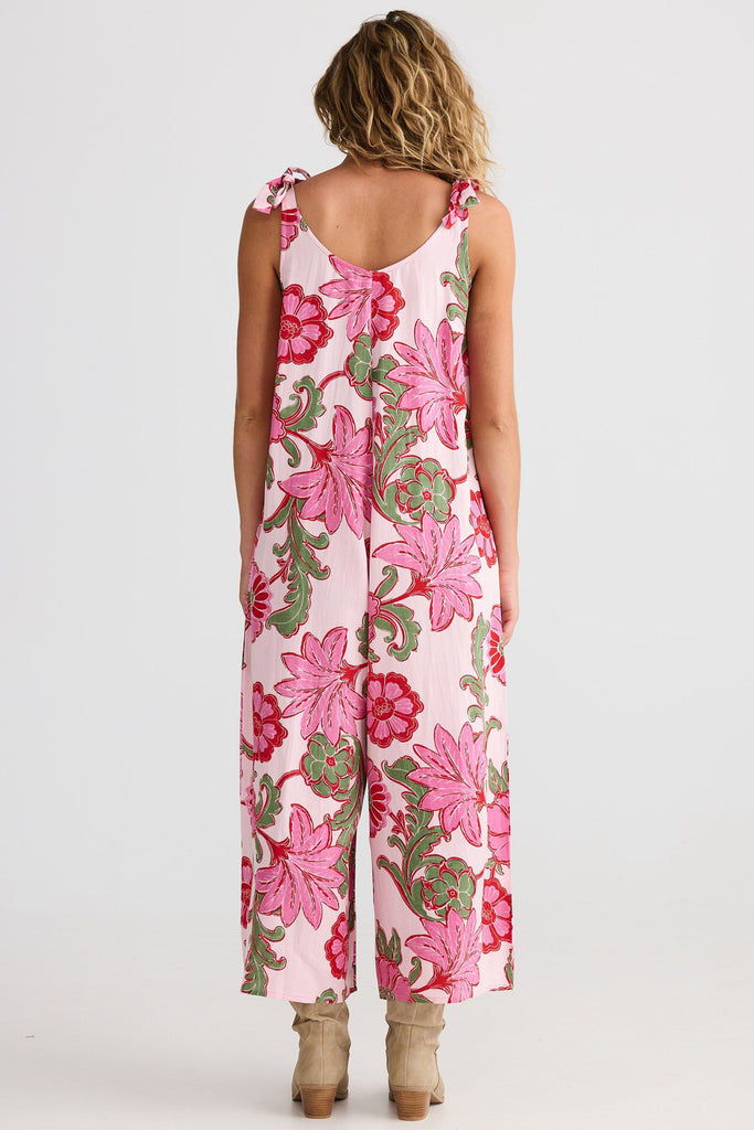 Woman wearing a floral jumpsuit on a white background
