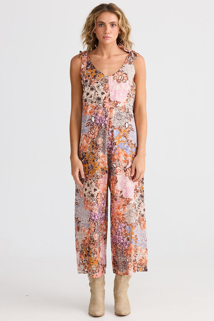 Woman wearing a floral jumpsuit on a white background