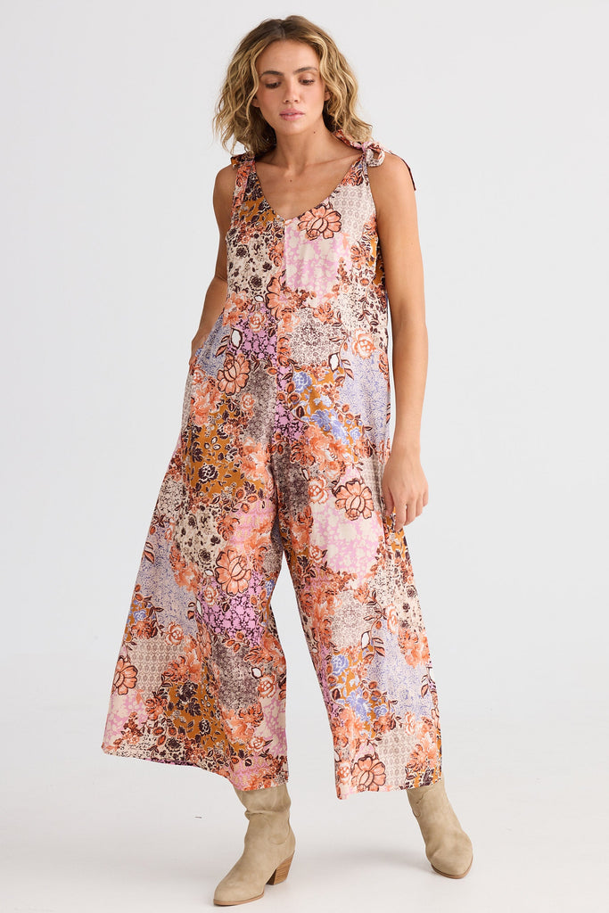 Woman wearing a floral jumpsuit on a white background