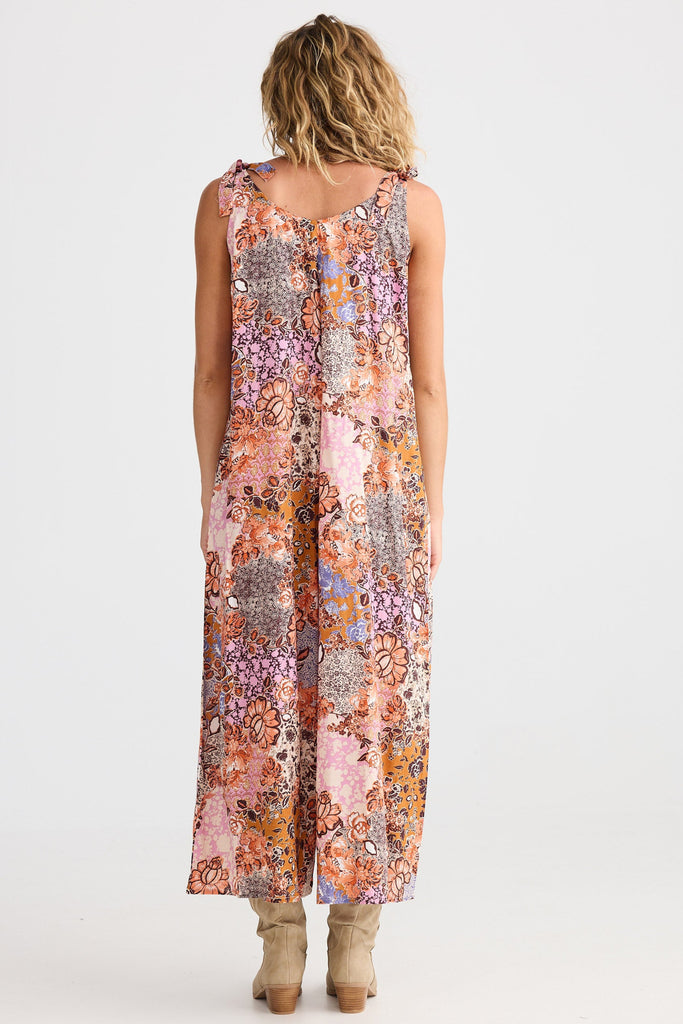 Woman wearing a floral jumpsuit on a white background