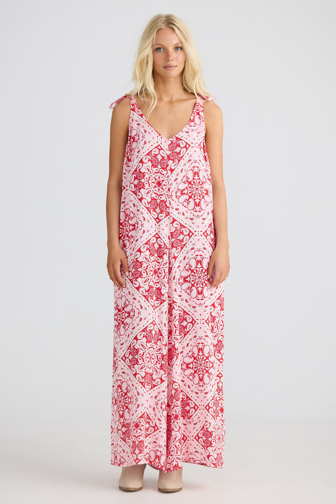Woman wearing a red and white paisley jumpsuit on a white background