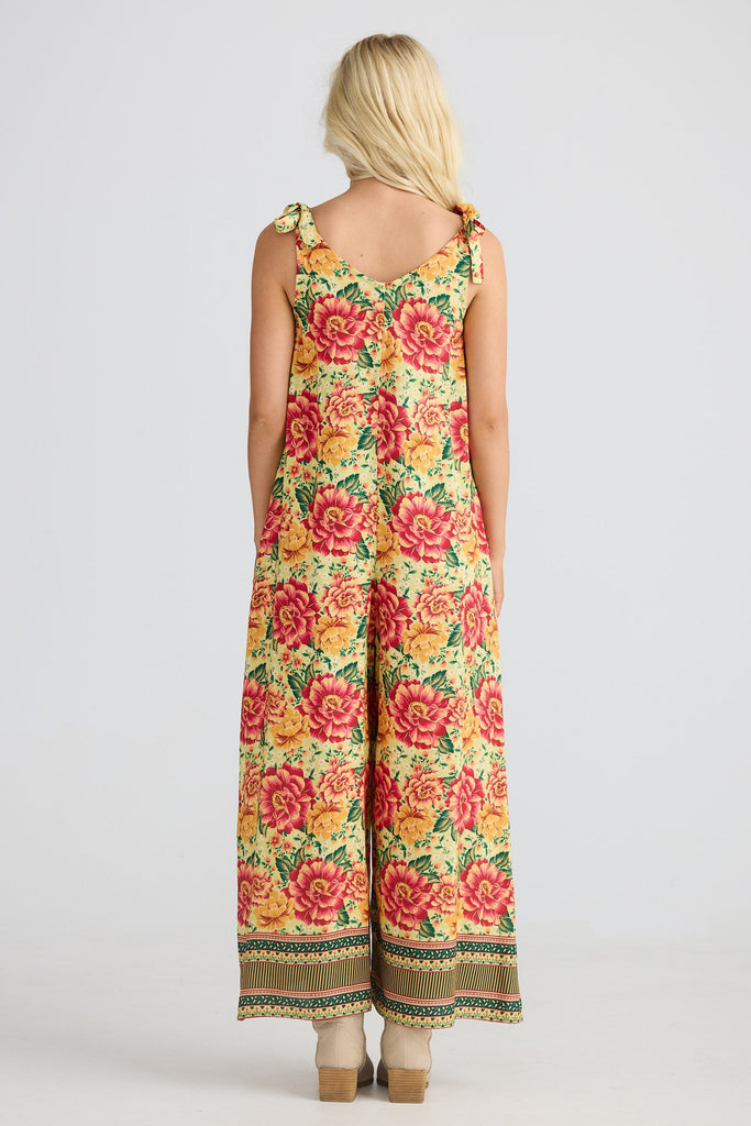 Woman wearing a floral jumpsuit on a white background