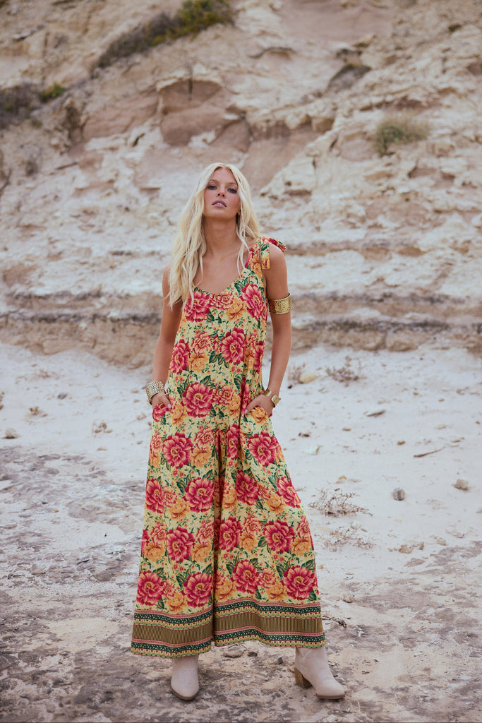 Woman in a floral dress standing in a desert landscape