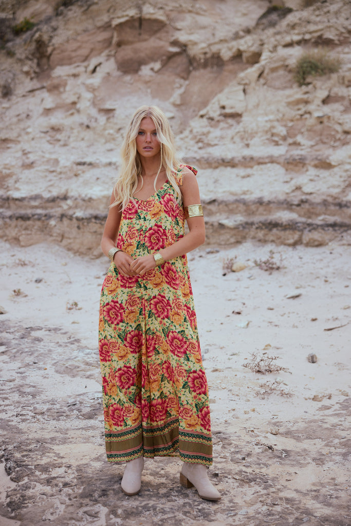 Woman wearing a floral dress standing in a desert-like setting