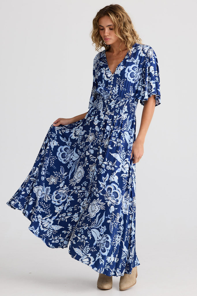 Woman wearing a blue floral dress on a white background