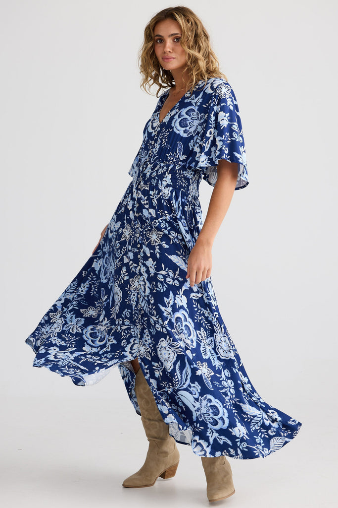 Woman wearing a blue floral dress on a white background