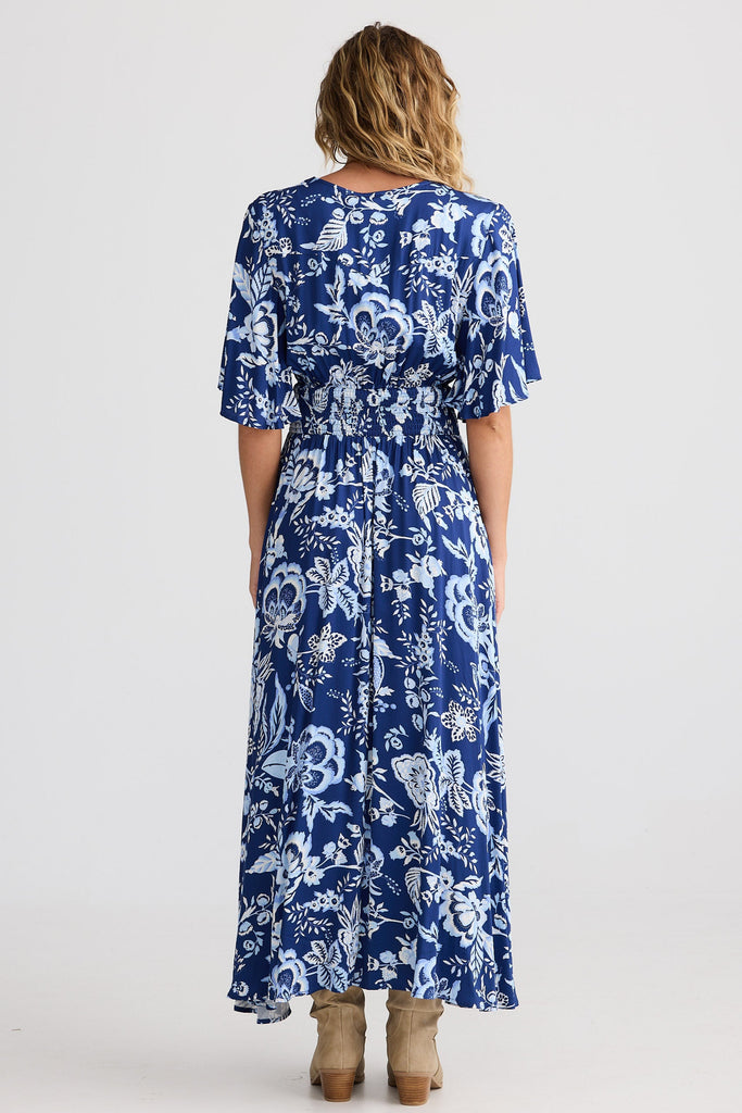 Woman wearing a blue floral dress on a white background