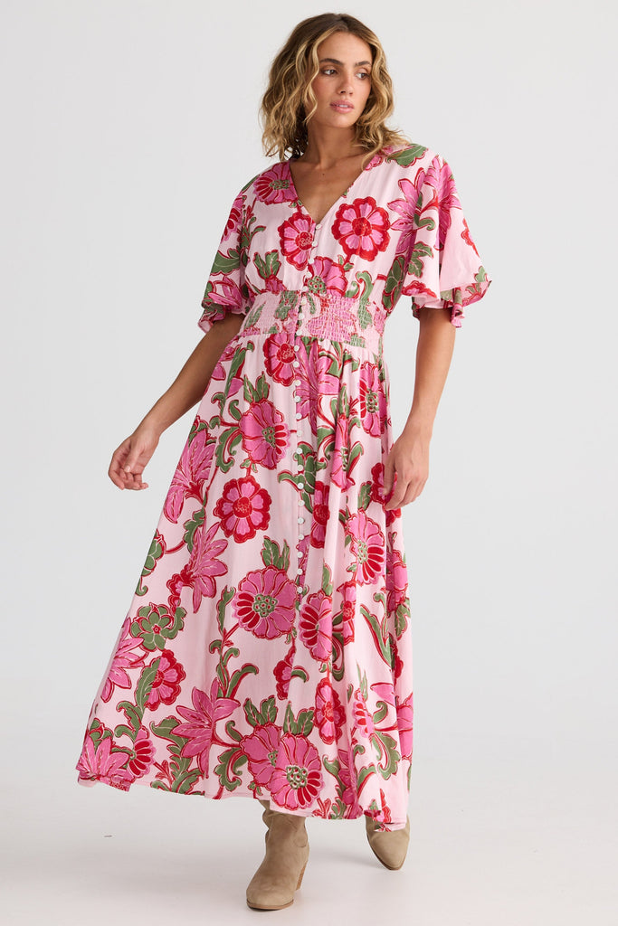 Woman wearing a pink floral dress on a white background