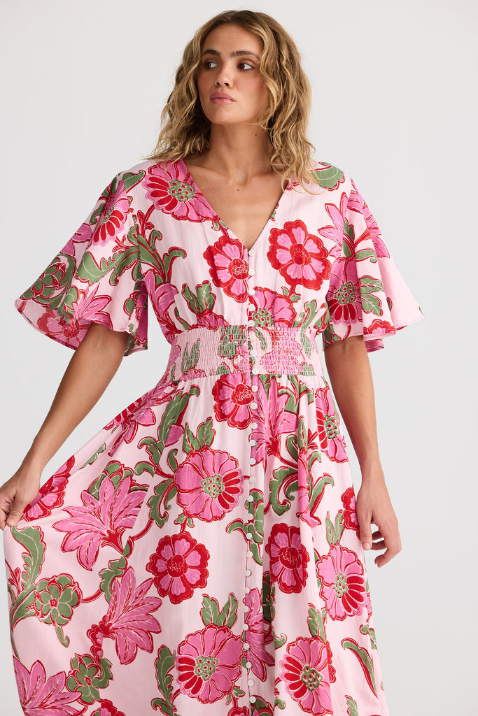 Woman wearing a pink floral dress on a white background