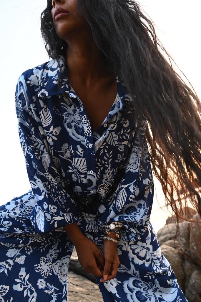 Person wearing a blue and white patterned garment with long hair.