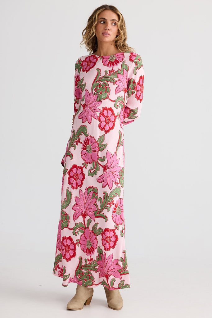 Woman wearing a floral dress with pink and green flowers on a white background