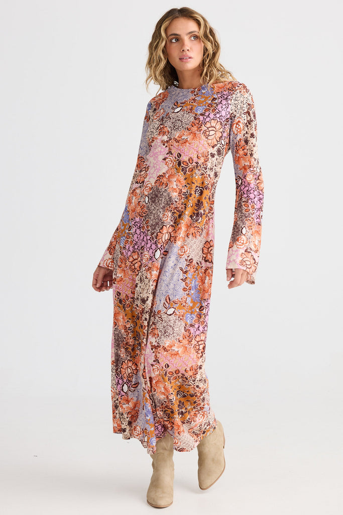 Woman wearing a long floral dress on a white background