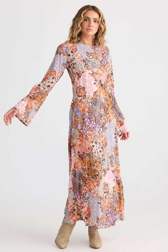 Woman wearing a long floral dress on a white background