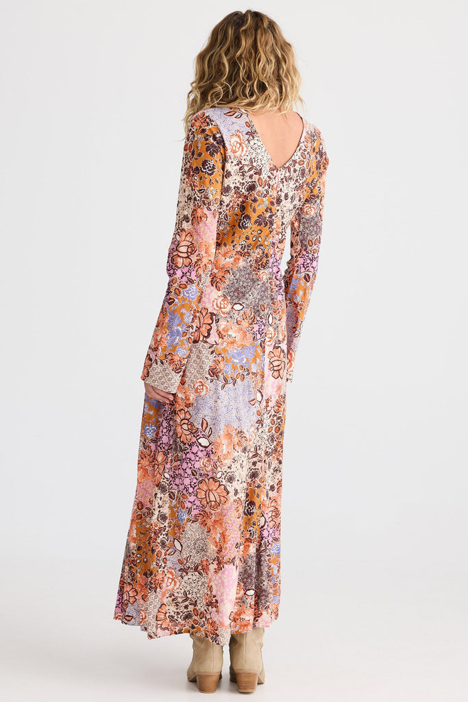 Woman wearing a long floral dress on a white background