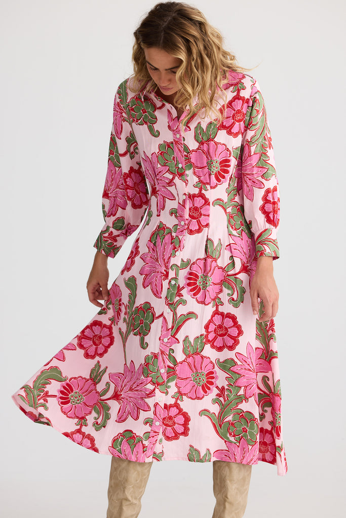 Woman wearing a pink floral dress on a white background