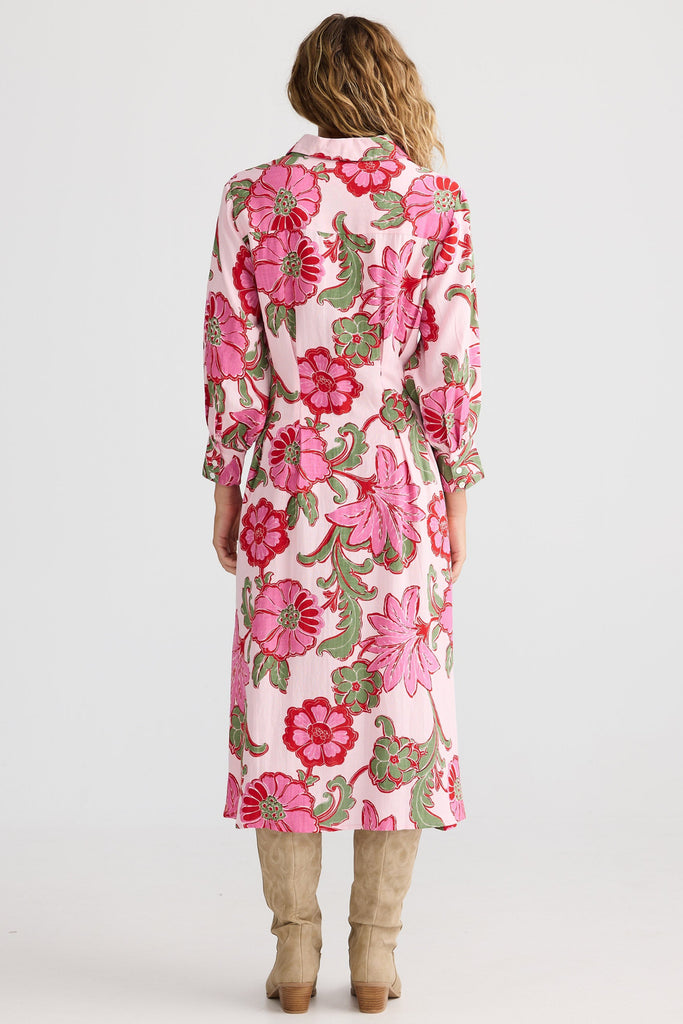 Woman wearing a long floral dress on a white background
