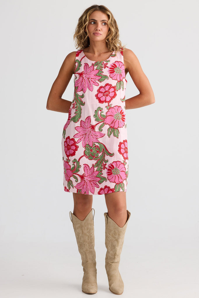 Woman wearing a floral dress with knee-high boots on a white background