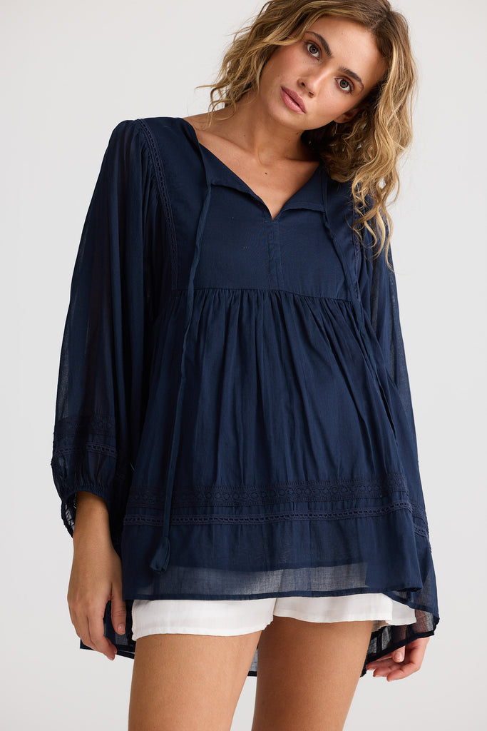 Woman wearing a navy blue blouse with a white background