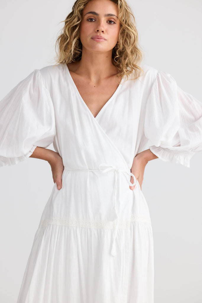 Woman wearing a white dress against a plain background