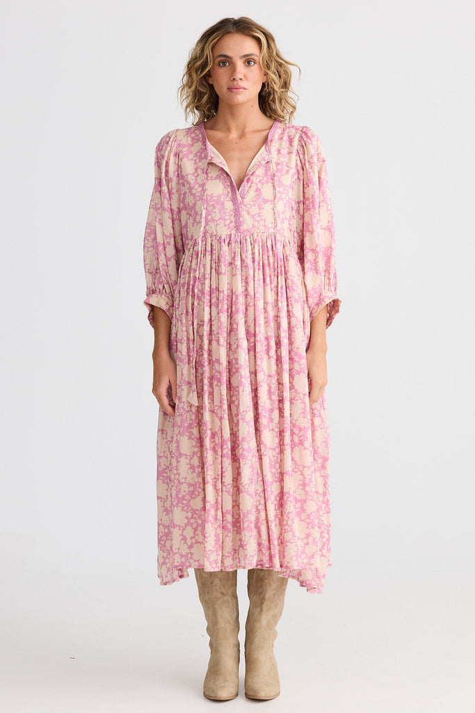 Woman wearing a pink floral dress on a white background