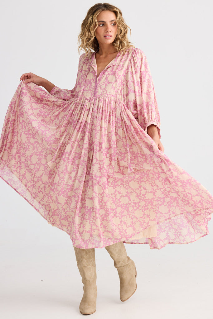 Woman wearing a pink floral dress on a white background
