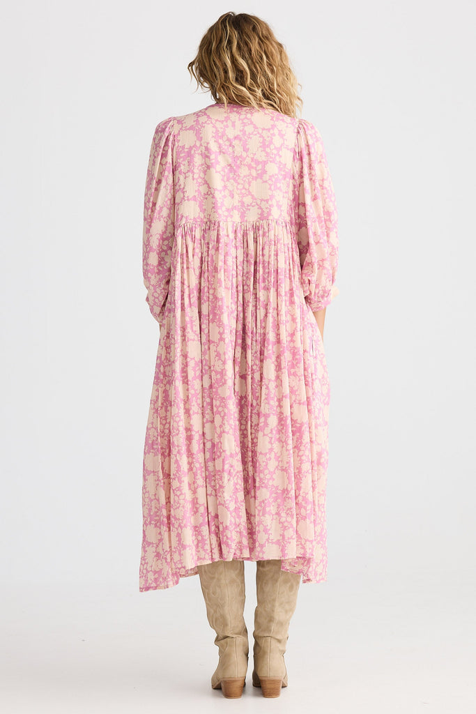 Person wearing a pink floral dress on a white background