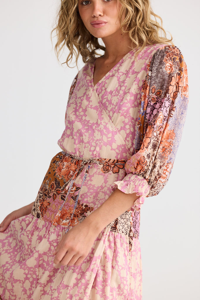 Woman wearing a pink floral dress with a white background