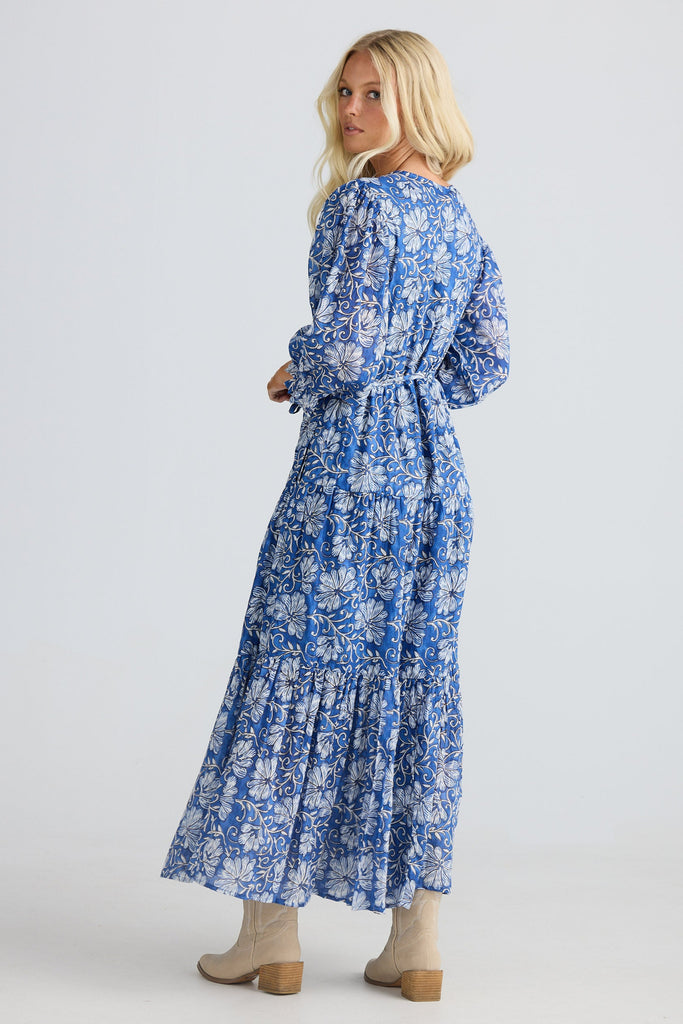 Woman wearing a blue floral dress on a white background
