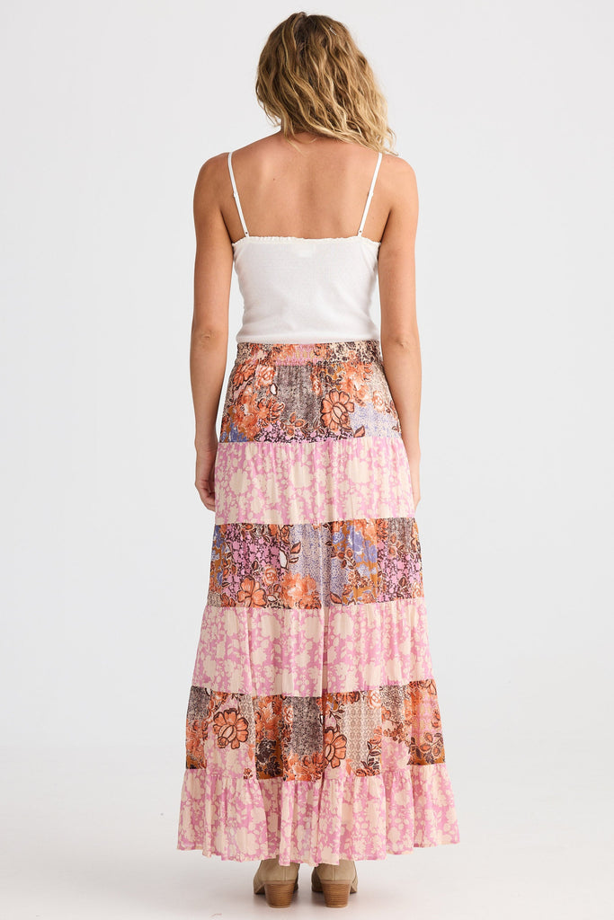 Woman wearing a floral patchwork skirt on a white background