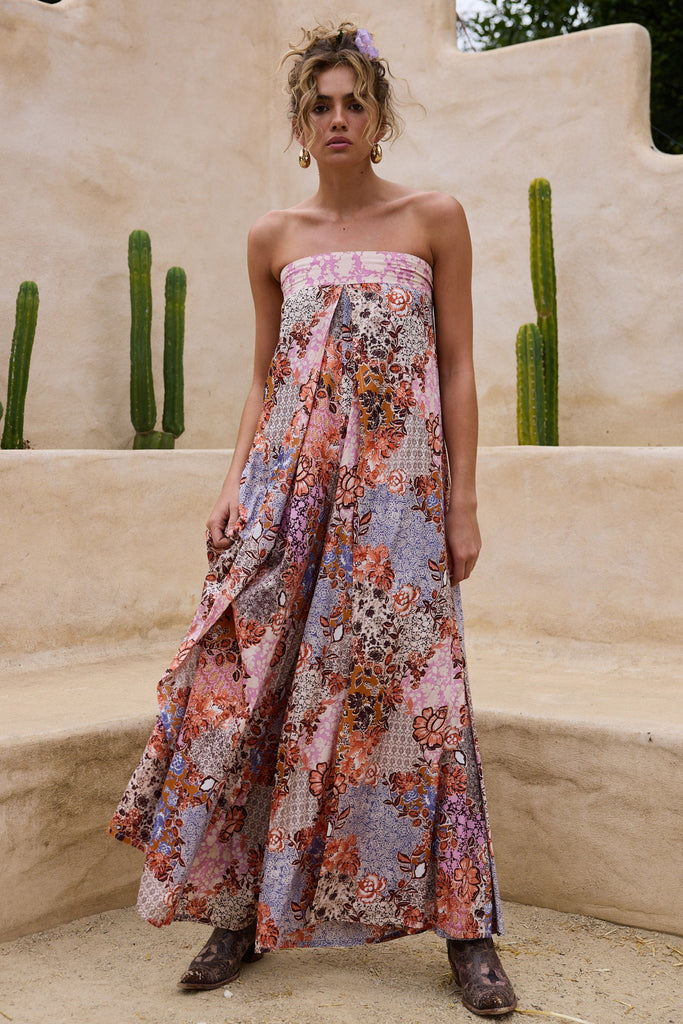 Woman in a floral strapless dress standing in front of a desert landscape with cacti.
