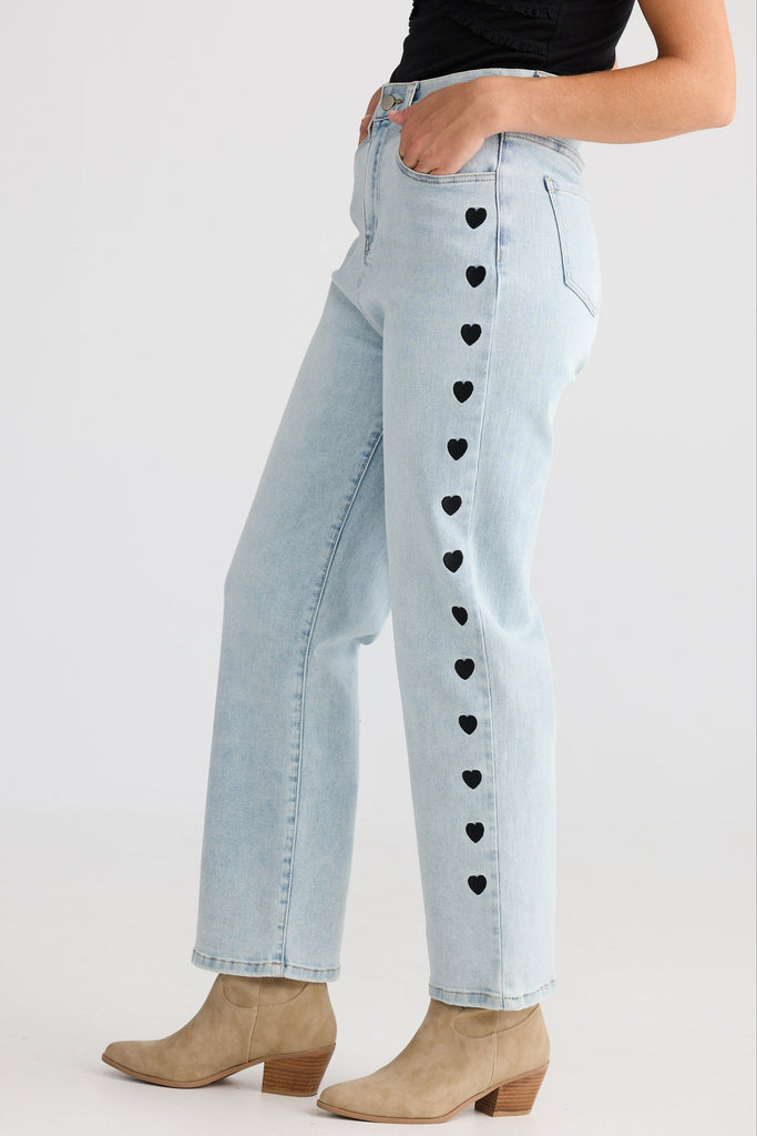 Light blue jeans with heart patterns on a white background