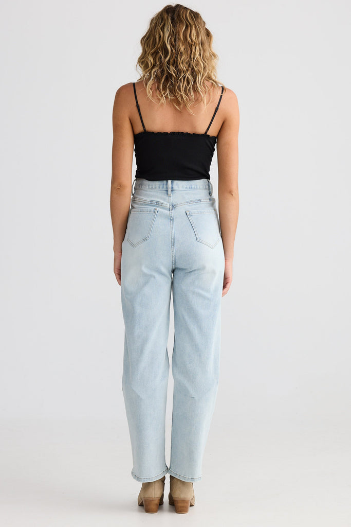 Person wearing light blue jeans and a black top on a white background