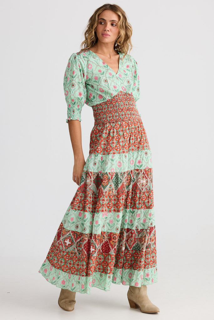 Woman wearing a floral dress with a tiered skirt on a white background