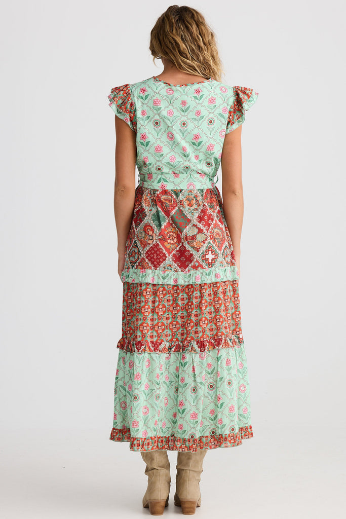Woman wearing a two-piece outfit with a patterned dress on a white background