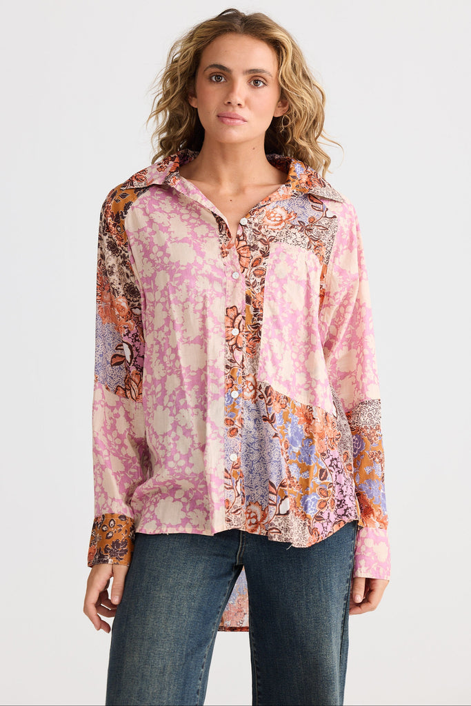 Woman wearing a colorful patterned shirt with a plain background