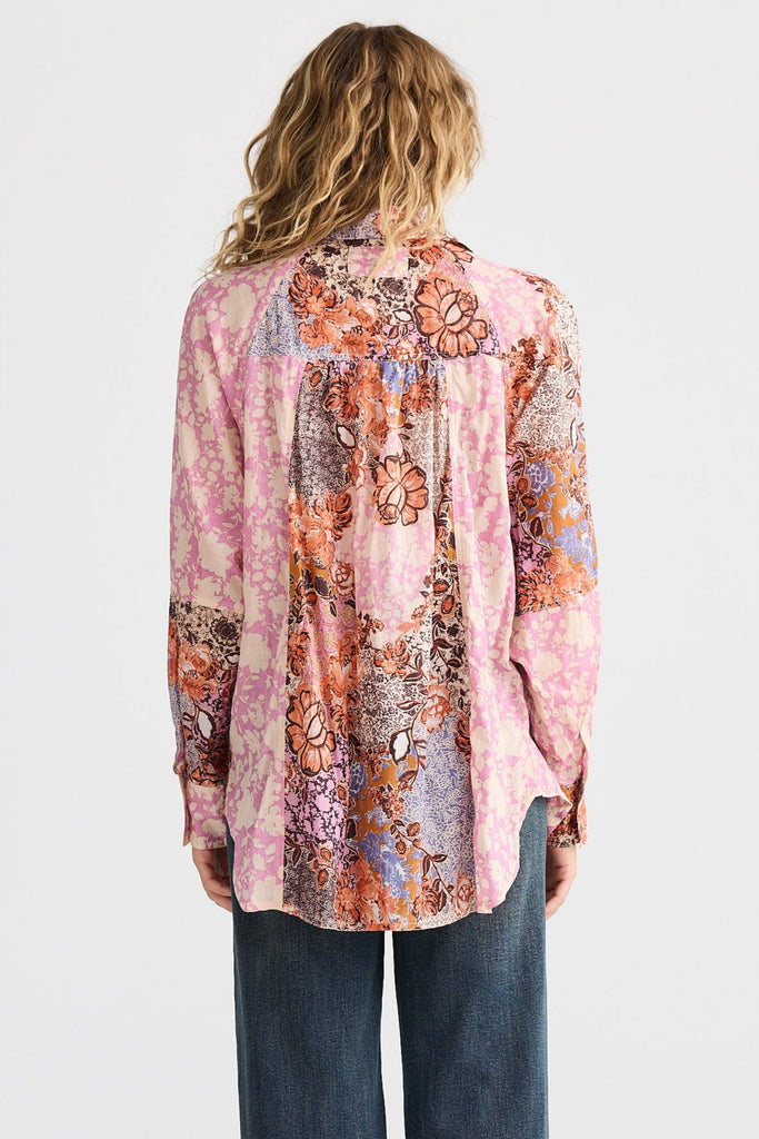 Person wearing a floral blouse and jeans on a white background