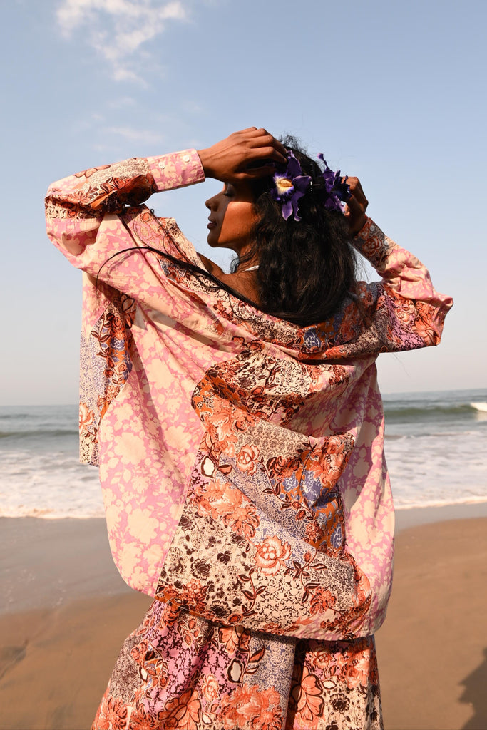 Woman in a patterned shirt against a blue sky with white clouds