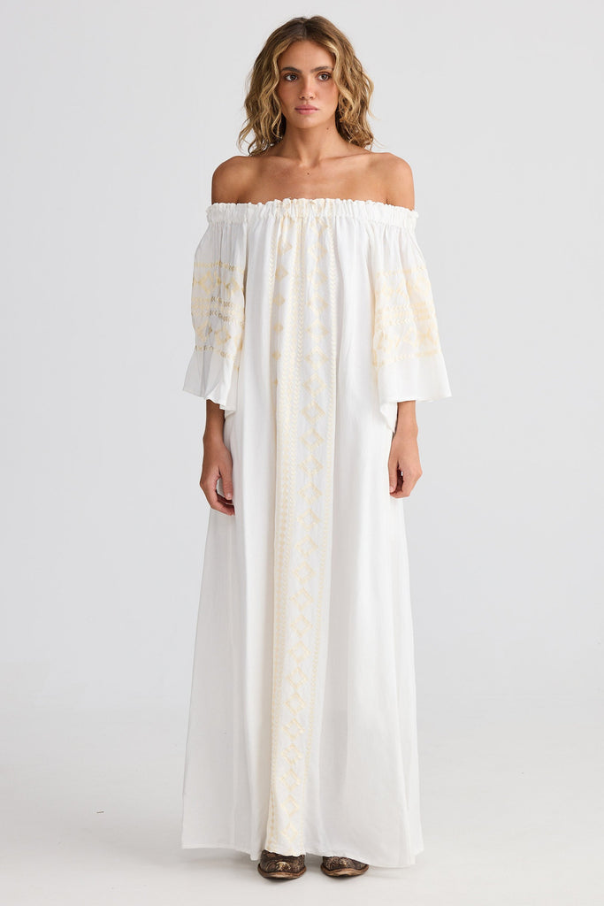 Woman wearing a white off-shoulder dress on a plain background