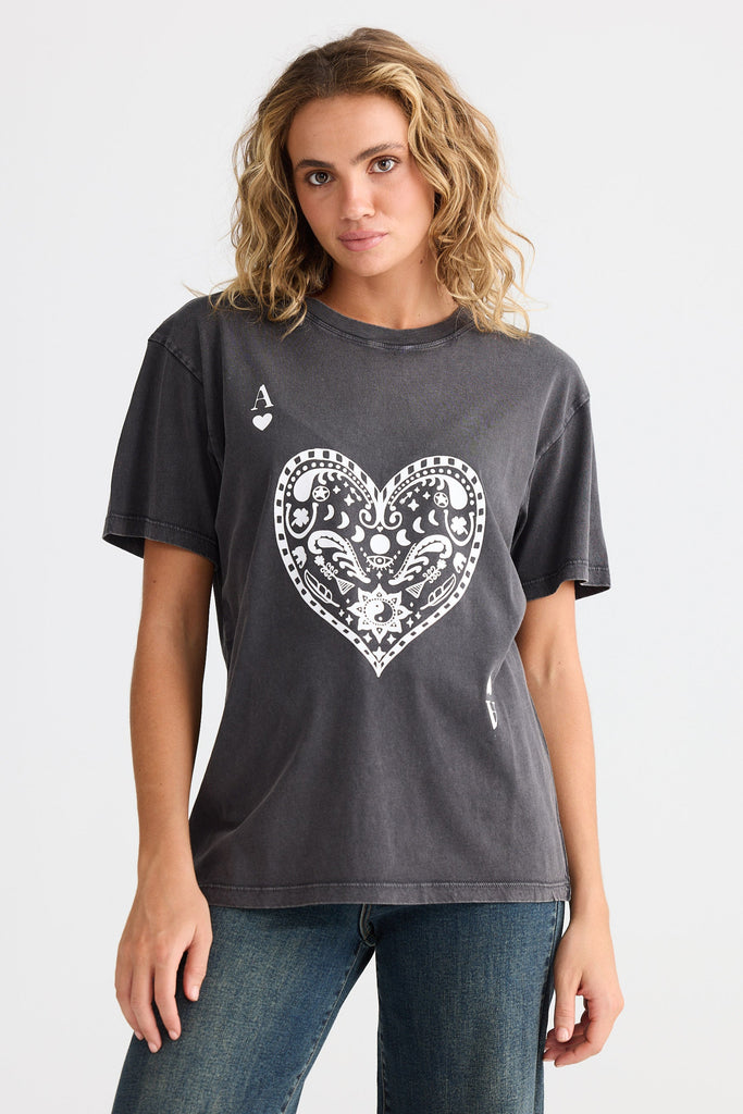 Woman wearing a dark gray t-shirt with a white heart design on a plain background