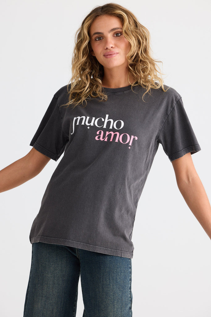Woman wearing a dark gray t-shirt with 'mucho amor' text on a white background