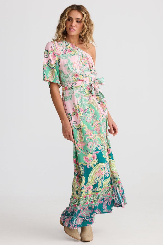 Woman wearing a floral one-shoulder dress on a white background