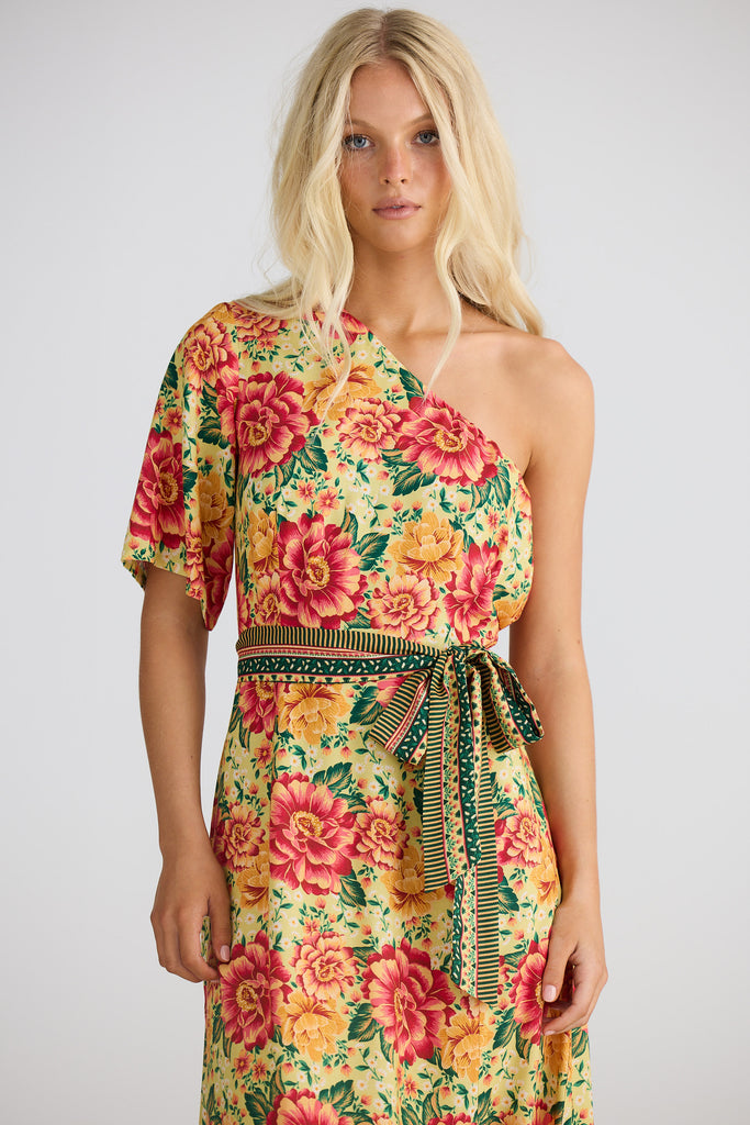 Woman wearing a colorful floral dress on a plain background