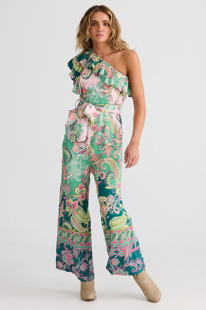 Woman wearing a colorful floral jumpsuit on a white background